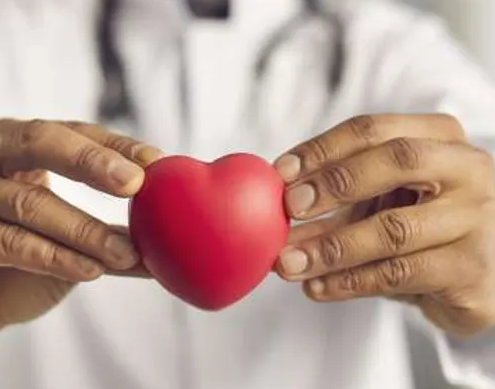 A person in a white coat holds a small red heart-shaped object with both hands, symbolizing care or health, reflecting the compassion found in integrative cancer care Calgary. A person in a white coat holds a small red heart-shaped object with both hands, symbolizing care or health, reflecting the compassion found in integrative cancer care Calgary.